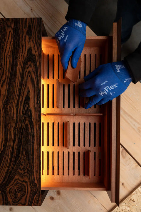 Humidor drawer with a slotted insert and warm LED light during assembly in the Litolite atelier