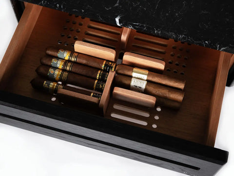 Open drawer of a Litolite humidor with a black marble top, showing cigars resting on the slotted wooden tray