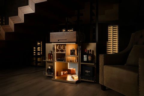 Bespoke bar and cigar cabinet lit by warm LED lighting in a private wine cellar